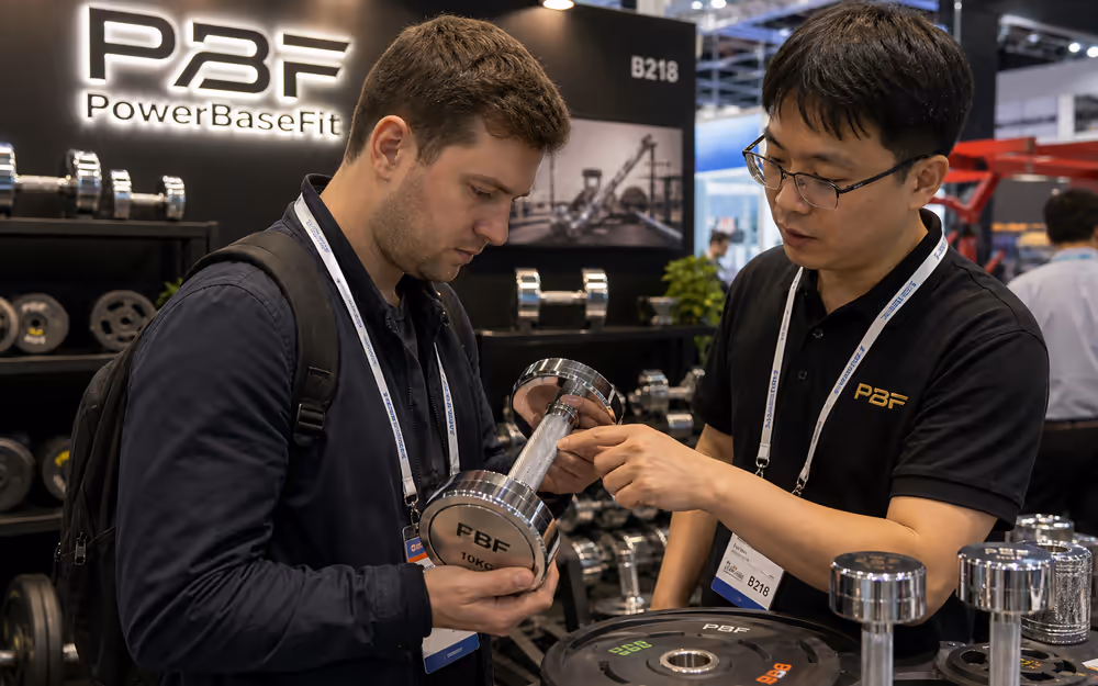 PowerBaseFit exhibition booth and overseas buyers reviewing free weight products