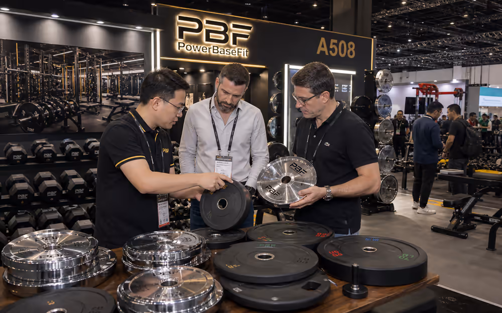 PowerBaseFit exhibition booth and overseas buyers reviewing free weight products