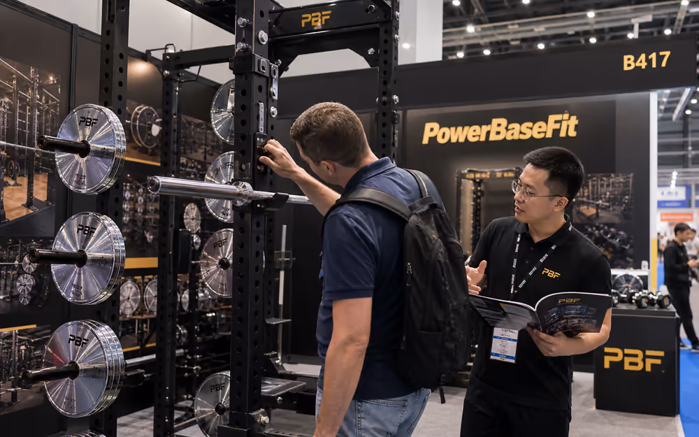 PowerBaseFit exhibition booth and overseas buyers reviewing free weight products