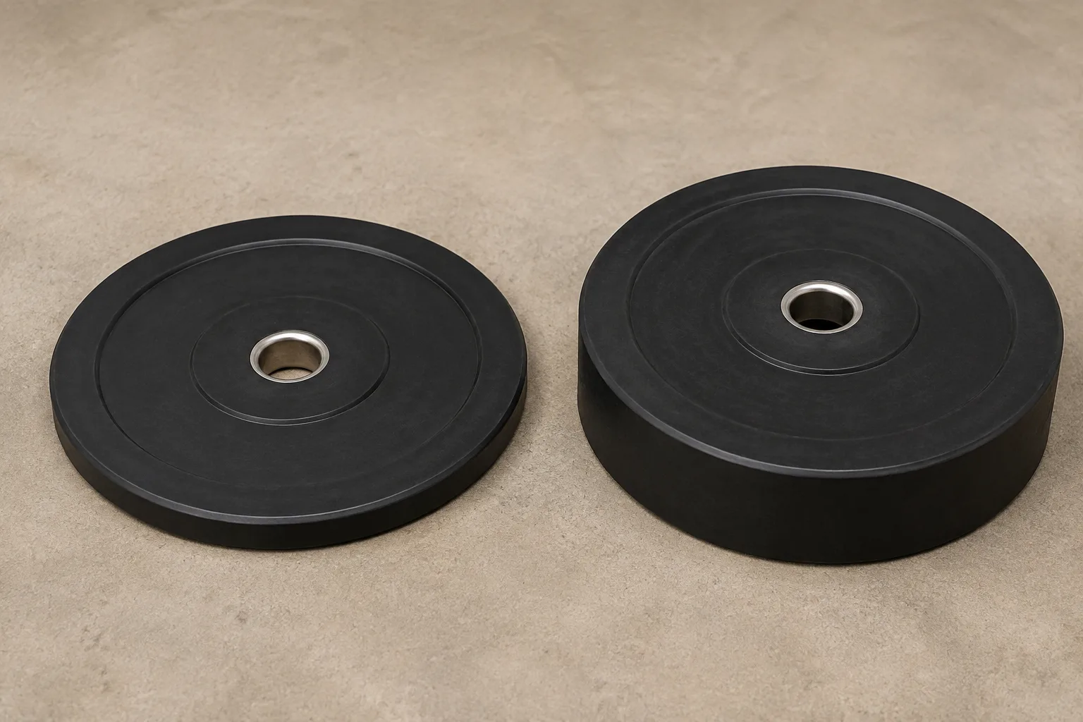 Two unmarked black weight plates with metal centre inserts