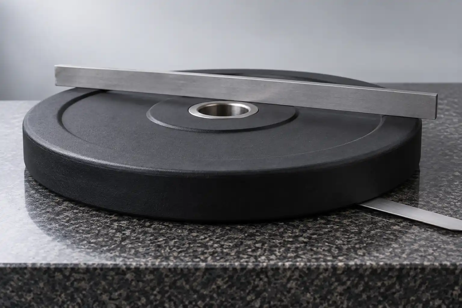 Disque olympique sans marque sur marbre avec règle pour contrôler la planéité